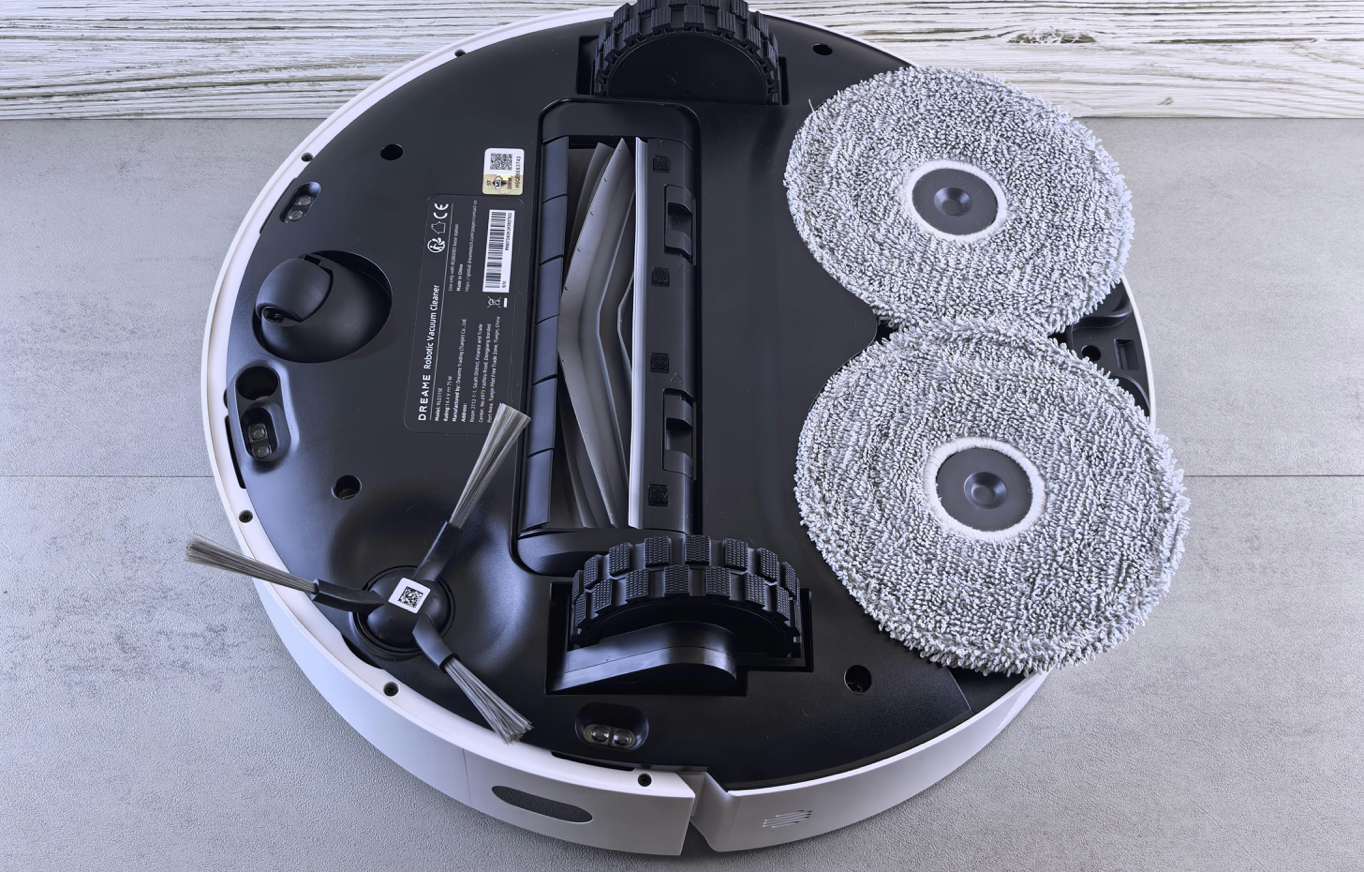 Detailed view of a robotic vacuum cleaner's underside showing brushes and wheels.